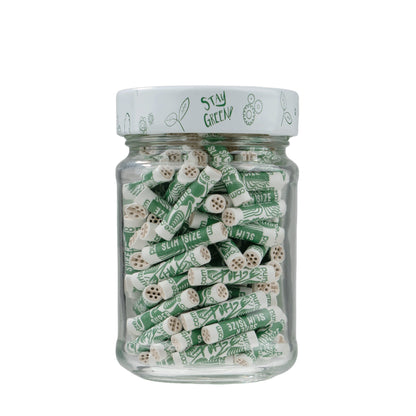 Jar of green and white cylindrical products with 'Stay Green' lid on a white background