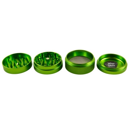 Green metal grinder with four parts on a white background