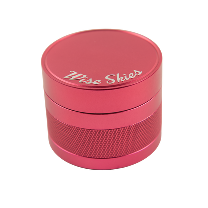 Pink metal grinder with 'Wise Skies' branding on a white background